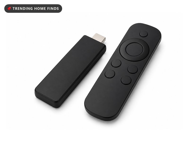 A small black streaming stick beside a slim black voice remote with a round control ring.