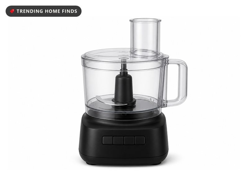 A black food processor base with a clear bowl, a steel S blade and a lid with a large feed chute.