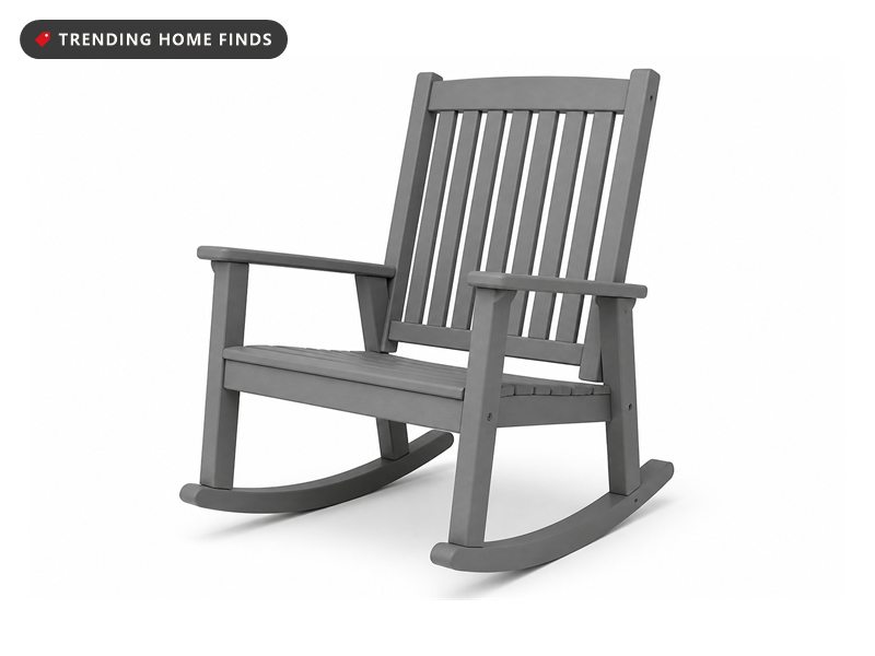 An oversized gray outdoor rocking chair with a tall slatted back, a wide slatted seat and curved rockers.