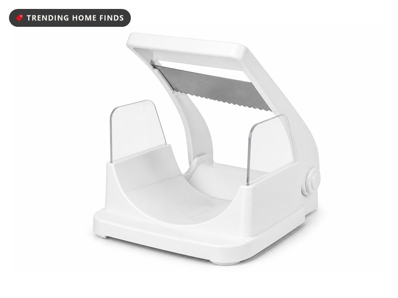 A white bagel guillotine slicer with a deep cradle, two clear acrylic shields and a serrated steel blade on a hinged handle.