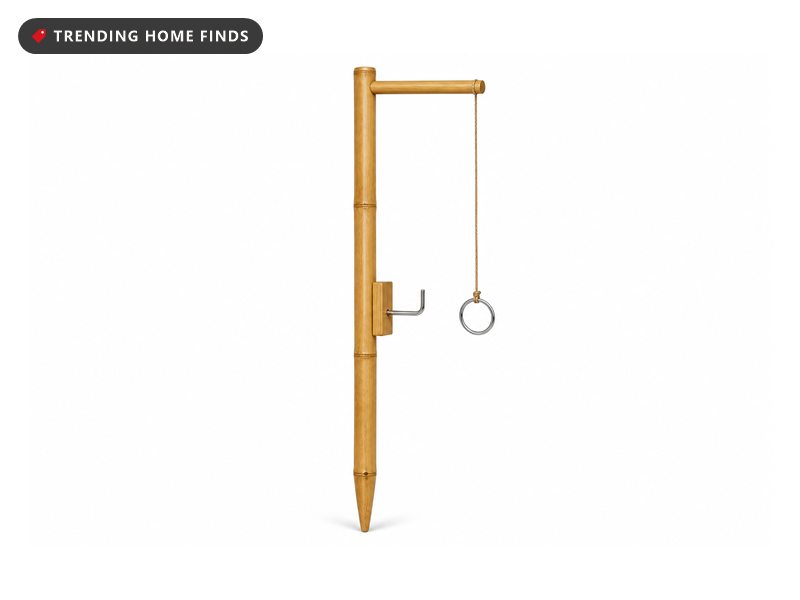 A bamboo hook and ring toss game with a tall pole, a hanging ring on a cord and a curved metal hook.