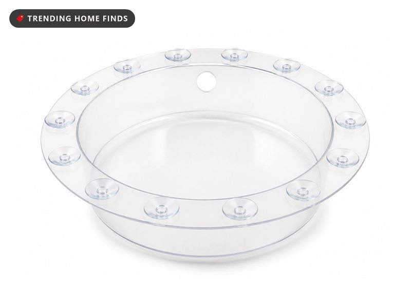 A clear round overflow drain cover with a flat rim and a ring of small suction cups.
