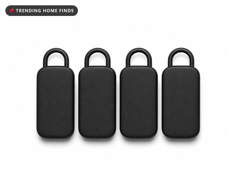 Four small black tracker tags with loops, laid out in a row.