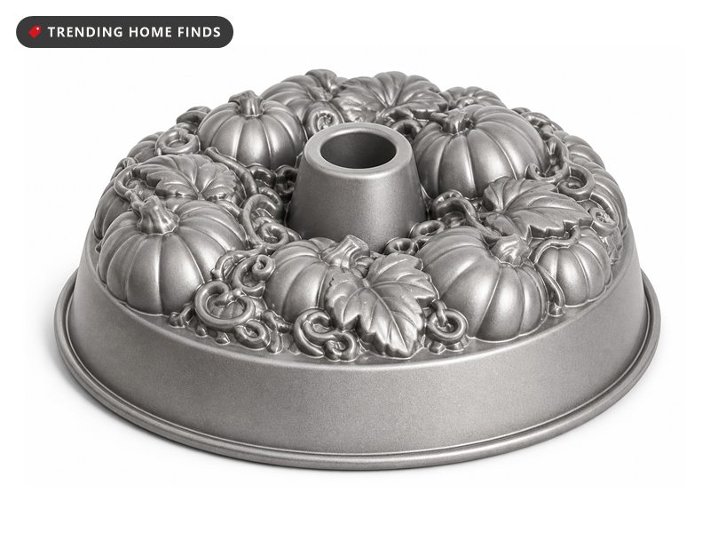 A cast aluminum bundt pan with a pumpkin patch relief pressed into the fluted interior.