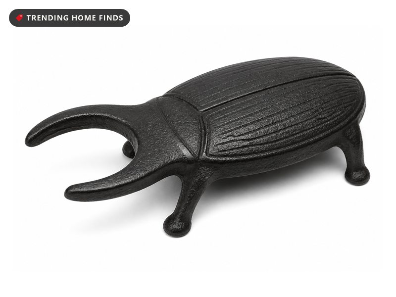 A black cast iron beetle shaped boot jack with two curved prongs forming a heel notch.