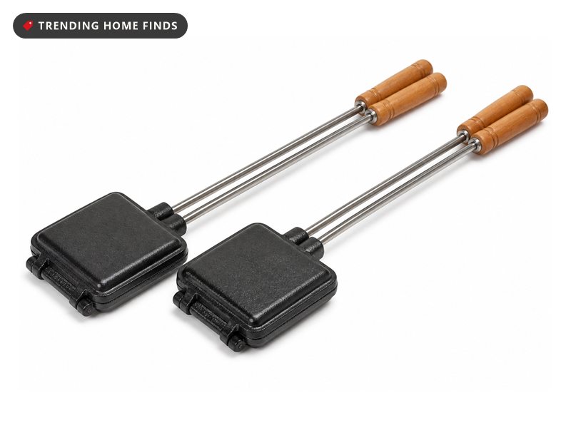 Two cast iron campfire pie irons with square heads and long wooden handles.