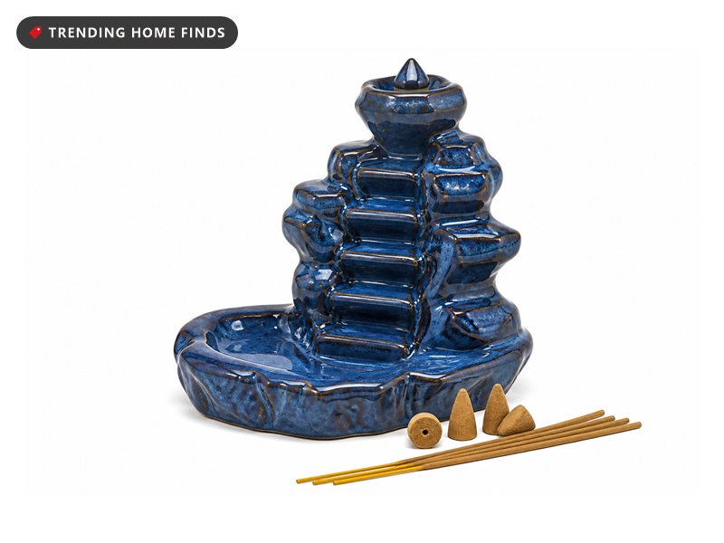 A blue glazed ceramic backflow incense burner shaped like stacked rocky ledges.