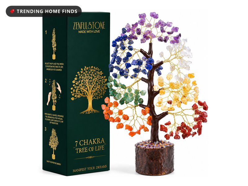 Decorative wire tree with seven colours of tumbled gemstone leaves on gold branches, on a carved wood base, beside its dark green gift box