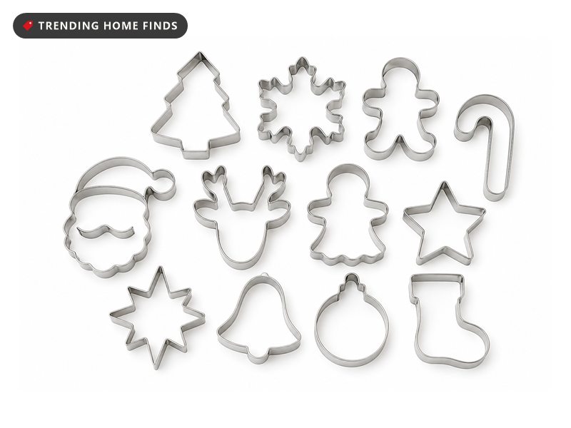 Twelve stainless steel Christmas cookie cutters in tree, snowflake, gingerbread and star shapes, laid flat.