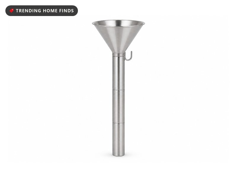 A slim stainless steel Christmas tree watering funnel in three joined sections with a wide cone at the top and a small hook below it.