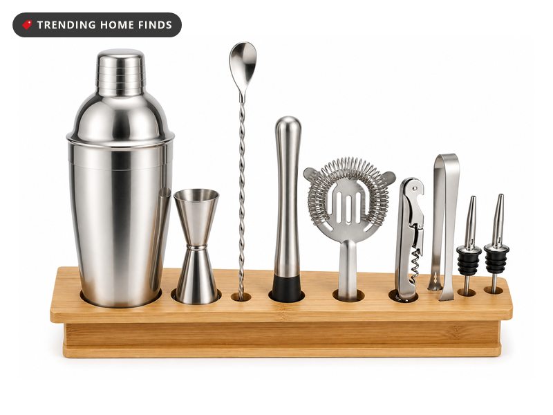 A cocktail set in a bamboo stand with a tall steel shaker, jigger, spoon, muddler and tongs.