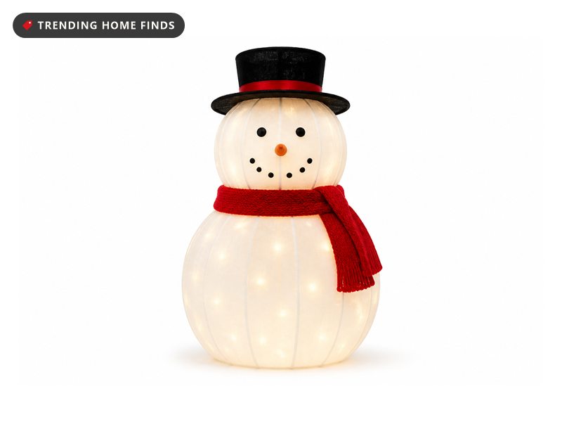 A lighted snowman with a black top hat and red scarf glowing warm white from inside.
