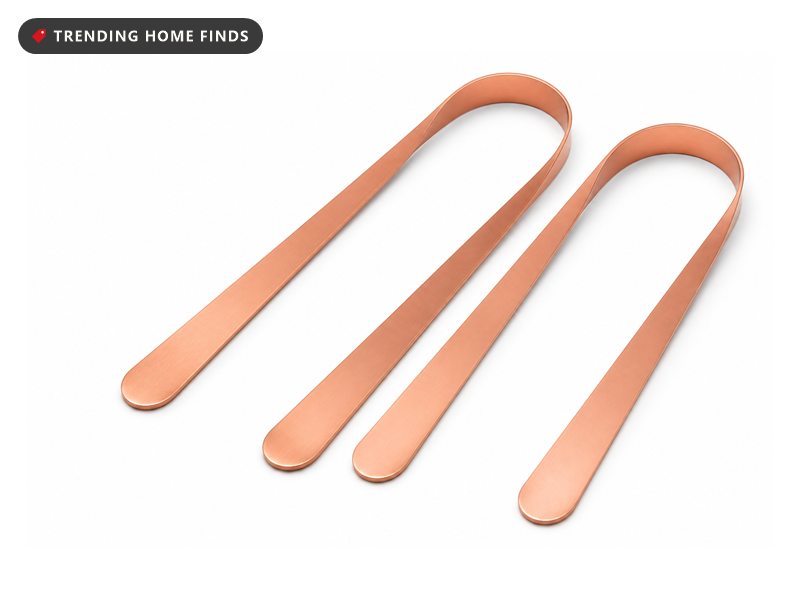 Two U shaped tongue scrapers of solid polished copper lying side by side.