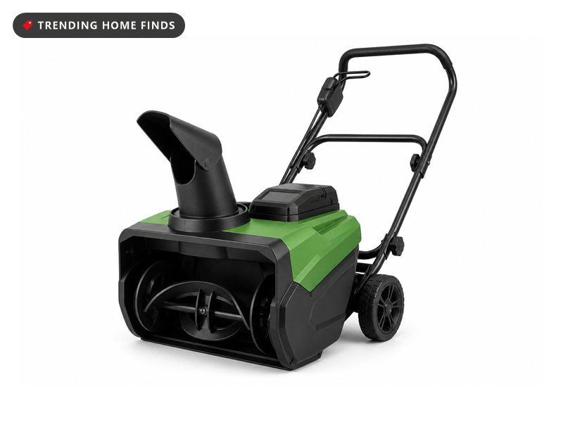 A green and black cordless snow blower on two wheels with a front intake, a top chute and a handle.