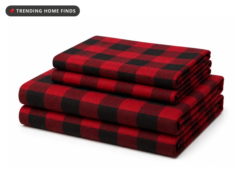 A folded stack of red and black buffalo check flannel sheets with two matching pillowcases.