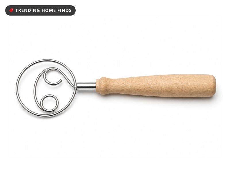 A Danish dough whisk with a flat looped stainless steel head and a turned light wood handle.