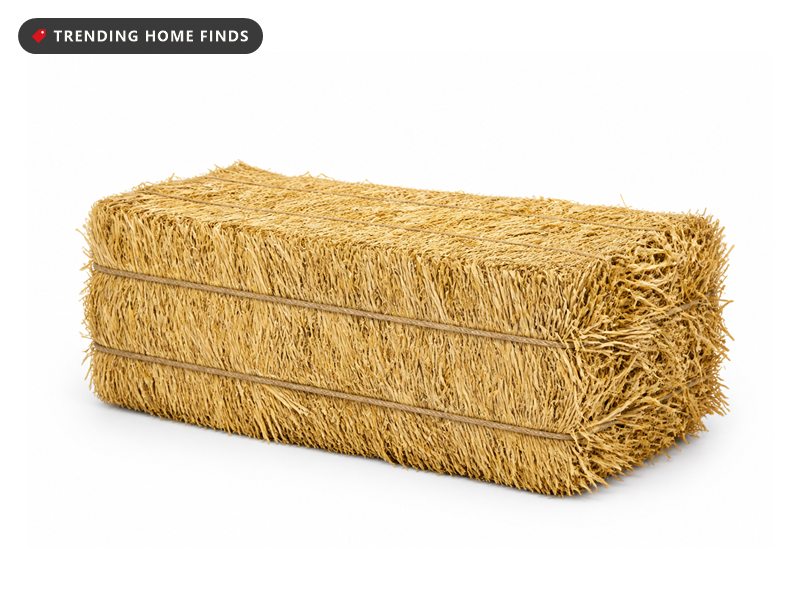 A rectangular bale of natural sun-dried straw, shown from a front three quarter angle.