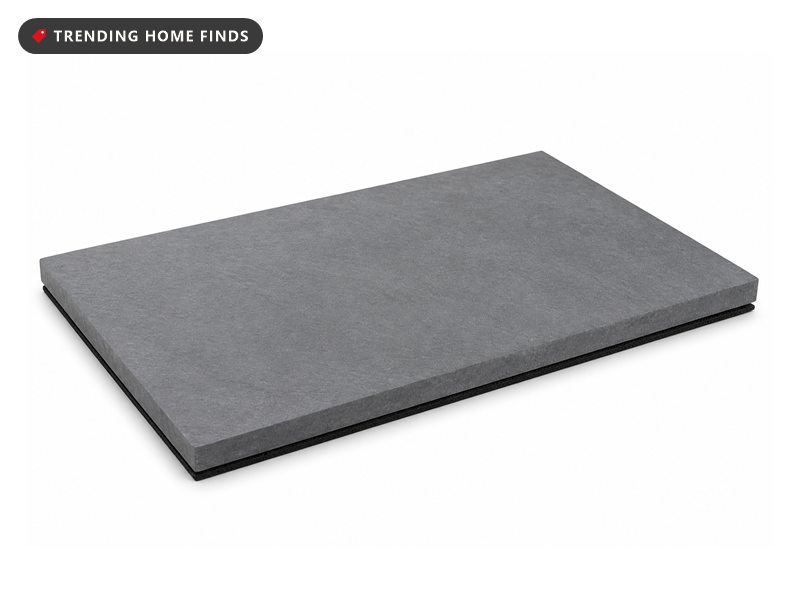 A rectangular slate gray stone bath mat with a fine matte surface and a dark non slip pad underneath.