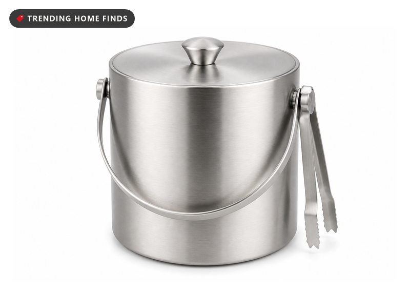 A round brushed stainless steel ice bucket with side handles, a fitted lid and tongs clipped to one handle.