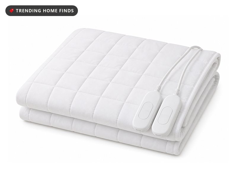 A white quilted heated mattress pad folded in half with two small handheld controllers.