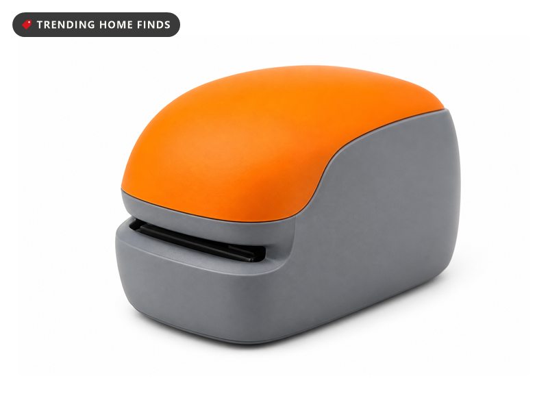 A compact electric stapler with a gray body, an orange top and a paper slot on the front.