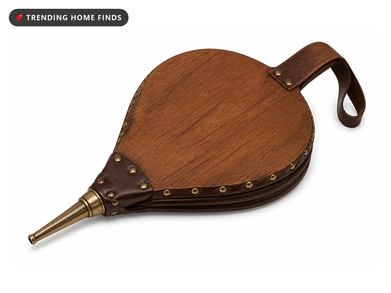 A wood and leather fireplace bellows with a metal nozzle and a hanging strap.