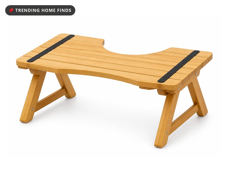 A foldable natural bamboo toilet stool with a curved inner edge, two folding legs and non slip strips.