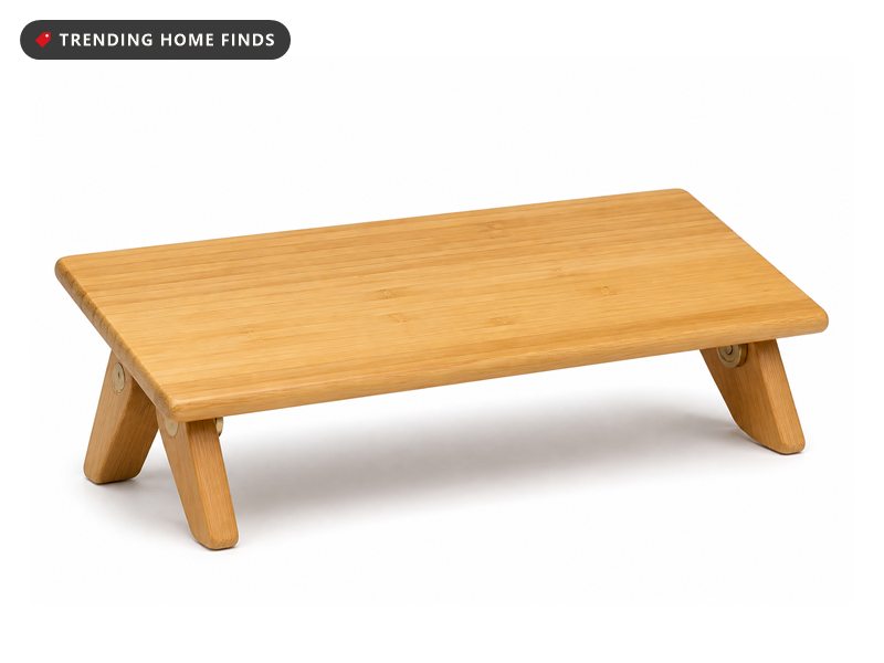 A low bamboo kneeling bench with a slightly tilted seat plank on two short folding legs.