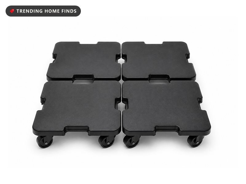 Four small square black furniture dollies on swivel wheels, arranged in a square.