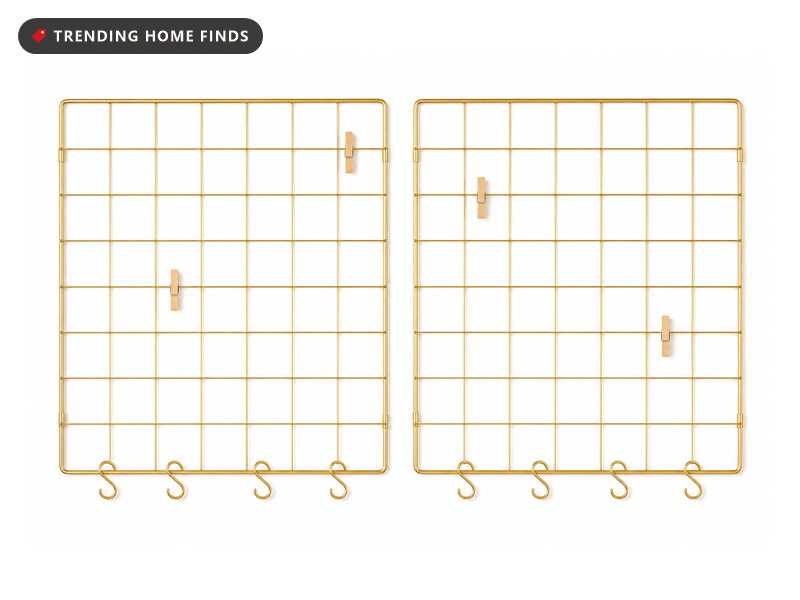 Two gold wire grid panels side by side with small S hooks and wooden clips on the wire.