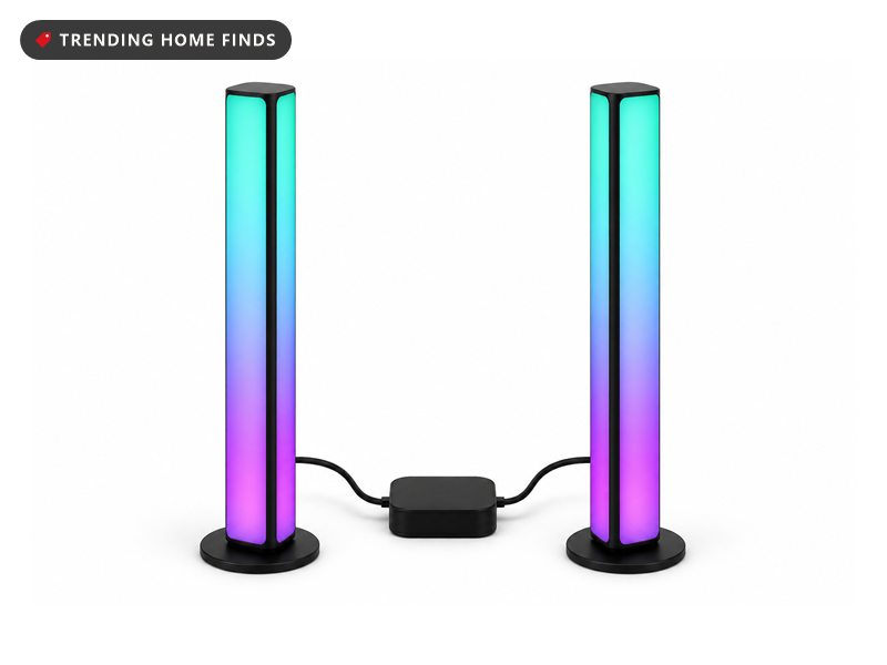 Two slim black light bars standing upright and glowing in a purple to teal gradient, a small controller box between them.