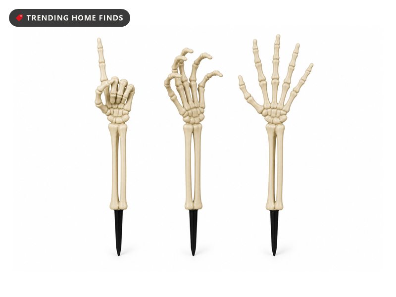 Three pale plastic skeleton hand yard stakes in pointing, grasping and reaching poses.