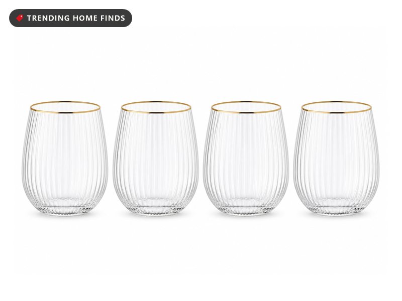 Four clear stemless wine glasses with fine vertical stripes and thin gold rims.