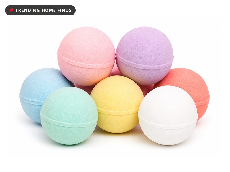 A cluster of large pastel bath bombs in pink, lavender, blue, mint, yellow, coral and white on a plain white background.