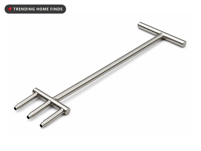 A long stainless steel core aerator with a crossbar handle at one end and three hollow tines at the other.
