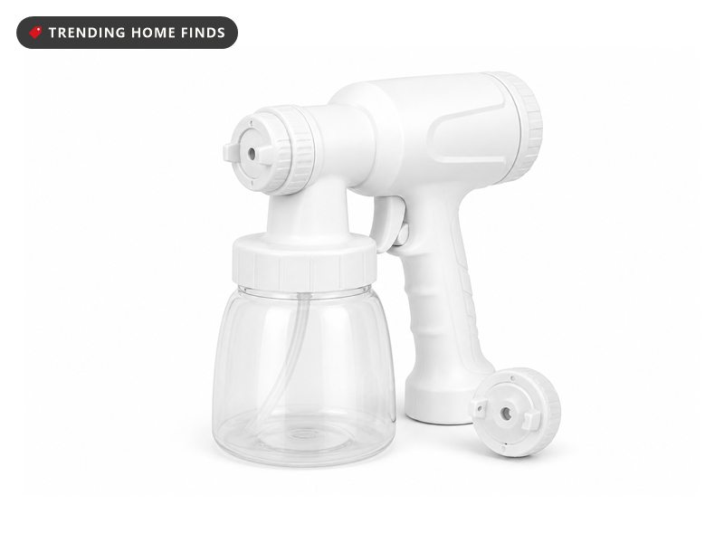 A white electric paint spray gun with a pistol grip, a front nozzle and a clear detachable cup.