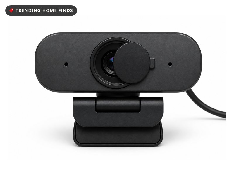 A compact graphite webcam on a folding clip mount with a round lens behind a small rotating privacy shutter.