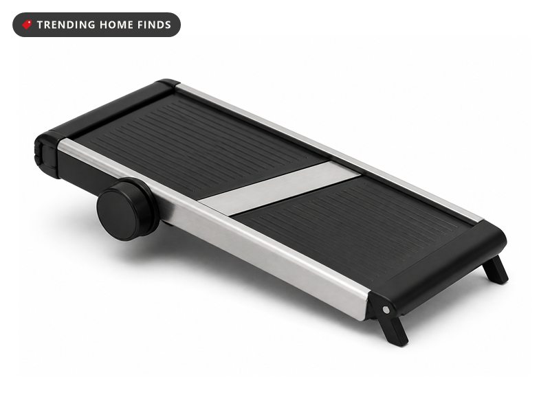A black and stainless steel mandoline slicer with a round adjustment dial and a folding leg.