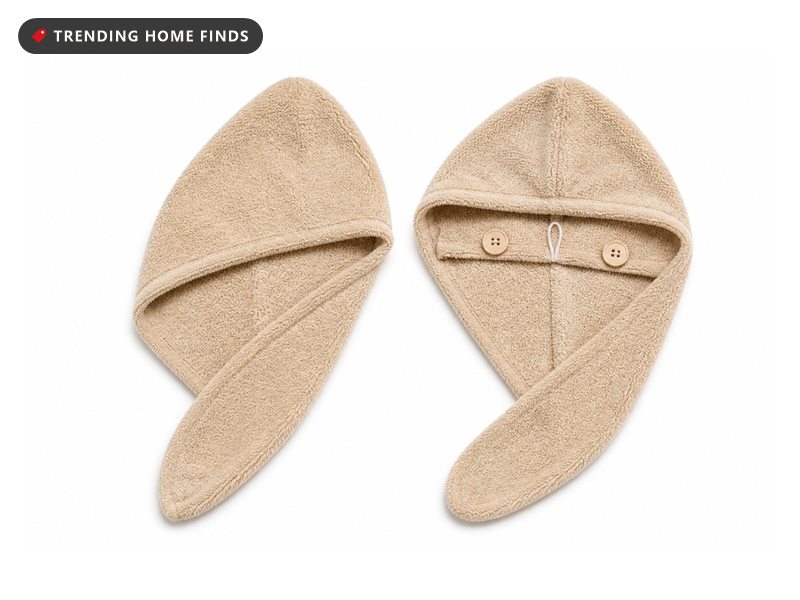 Two beige microfiber hair towel wraps, folded and stacked, with the buttons and elastic loop showing.