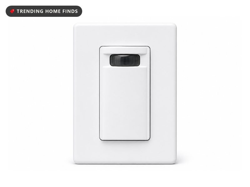 A white motion sensor wall light switch with a dark oval sensor lens on its paddle.