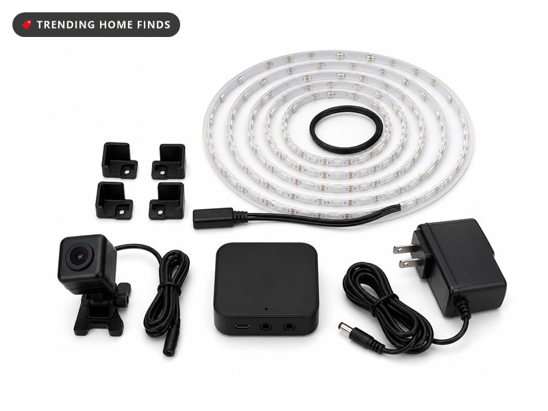 A coiled LED light strip, corner brackets, a controller and a small clip on camera laid out together.