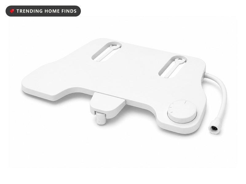 A white slim bidet attachment plate with a nozzle housing and a side control dial.