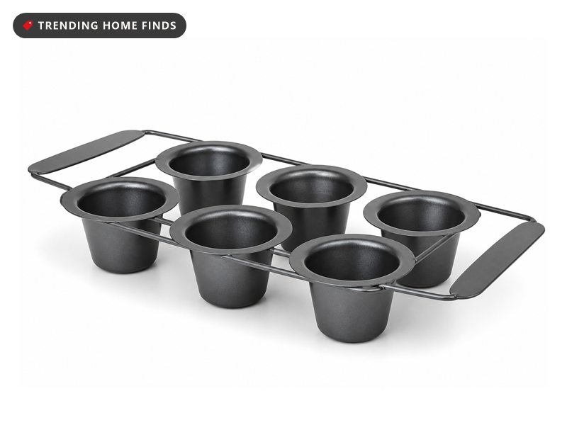 A six cup dark gray nonstick popover pan with deep cups held apart in an open steel frame.