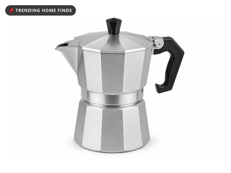 An eight sided brushed aluminum moka pot with a faceted lower chamber, a hinged lid, a pouring spout and a dark handle.