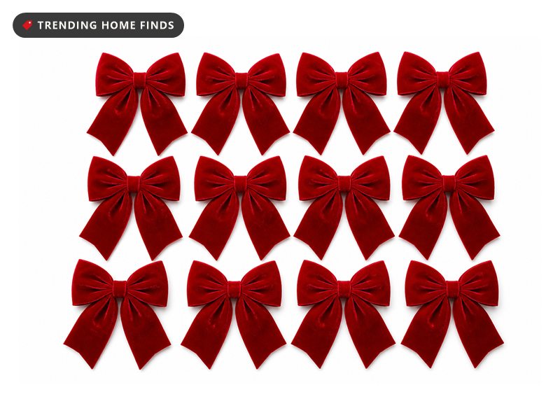 Twelve large red velvet bows with long tails laid out in three rows of four.