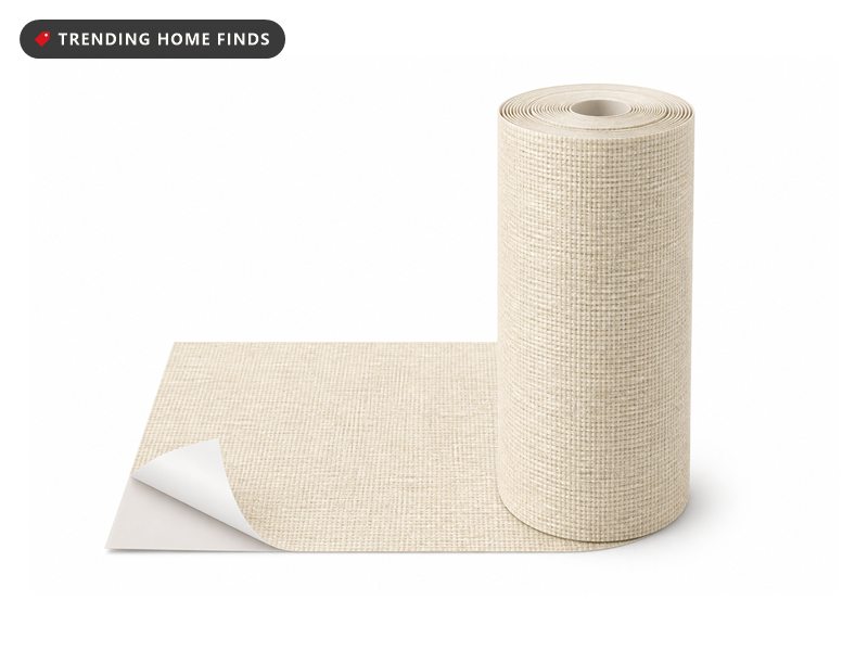 A roll of cream woven grasscloth textured wallpaper with a corner of its backing peeled away.
