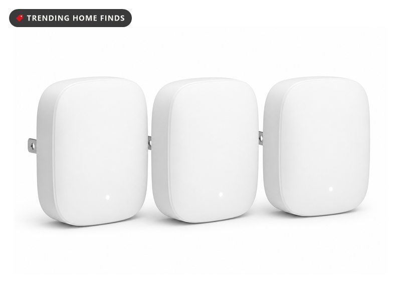 Three small rounded white plug in mesh WiFi units, each with a folding plug and a small status light.