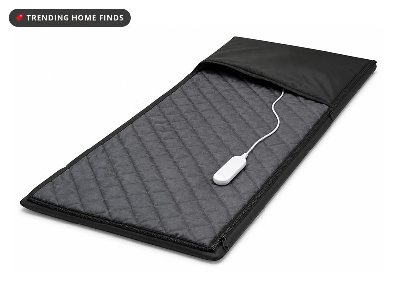 A black infrared sauna blanket unzipped and folded open, showing a gray lining.