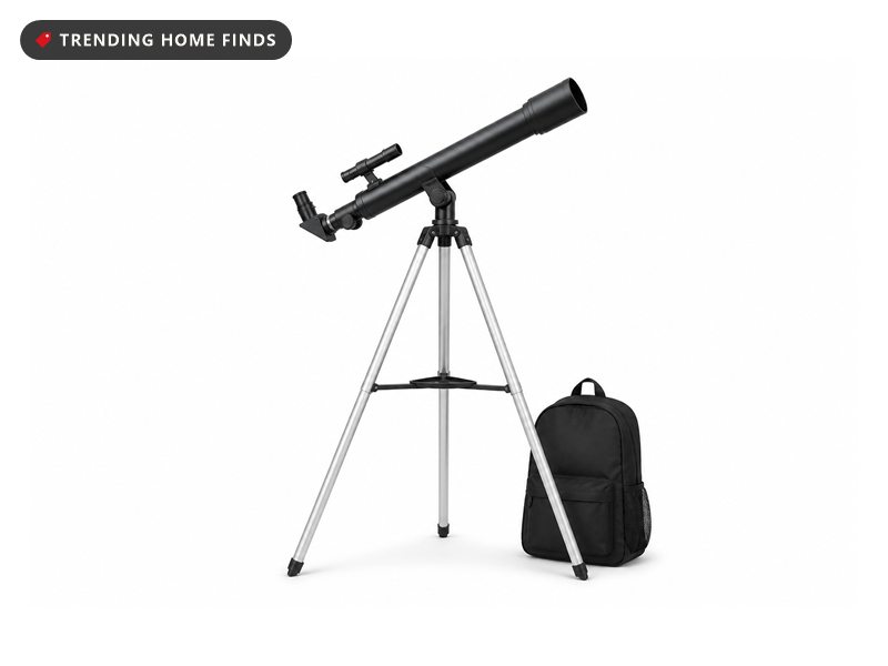 A slim black refractor telescope on a silver tripod with a finderscope on top and a backpack beside it.
