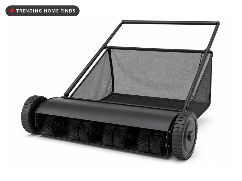 A push lawn sweeper with a 26 inch brush housing, rubber wheels and a mesh collection bag behind it.